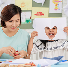 Teacher next to laughing student with heart cut-out