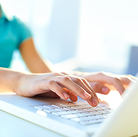 Female hands navigating on a laptop